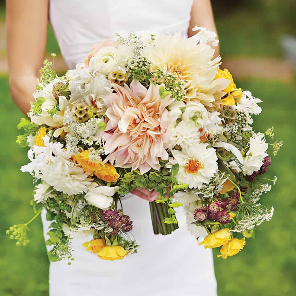 Cascading bouquet with orange, white and pink hued florals.