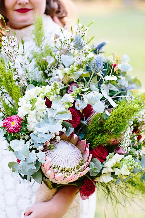 Native floral wedding bouquet with pops of red and pink
