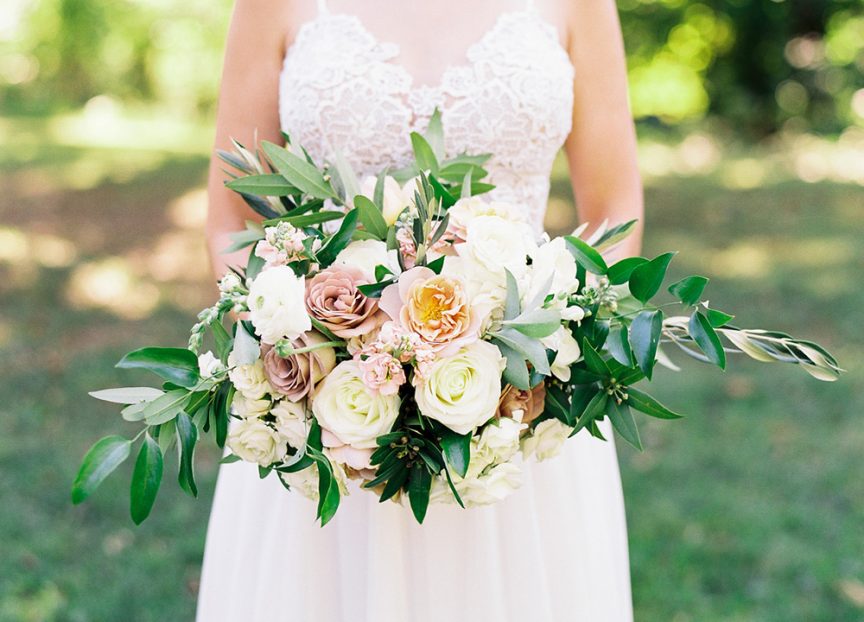 Cascade bouquet featuring garden roses, ranunculus rose, snapdragon & bay leaves.