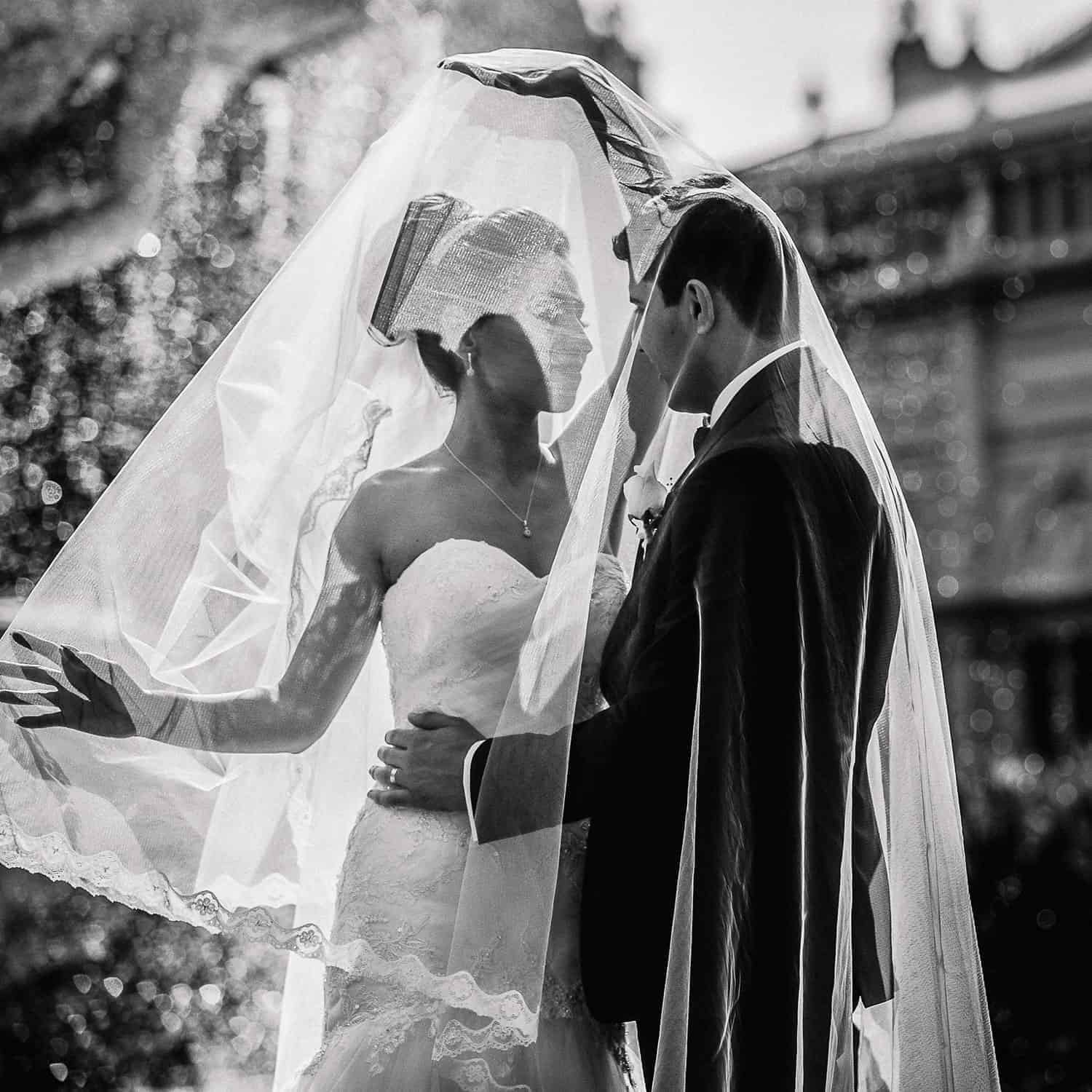 Bride and groom under veil in black and white