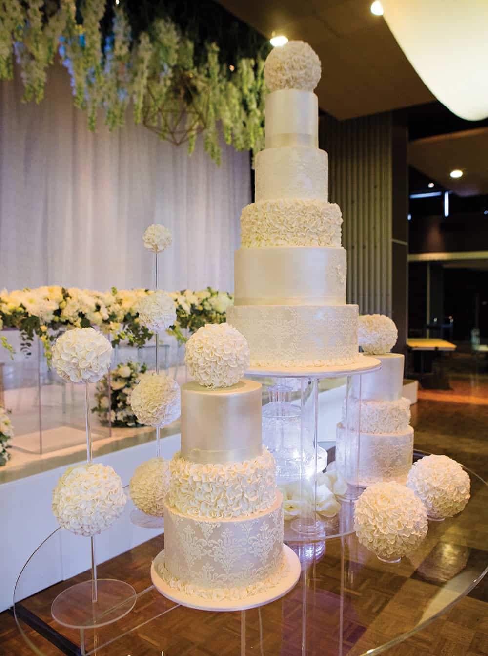 Acrylic tables with wedding cakes and florals.