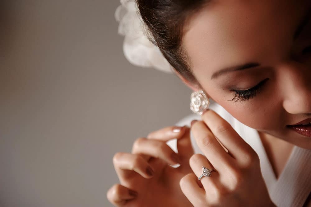 beautiful bride putting on earings