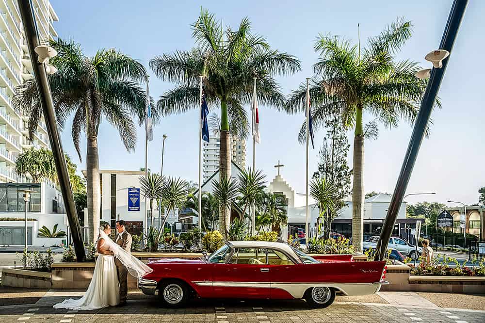 wedding couple with red car by Christopher Thomas Photography
