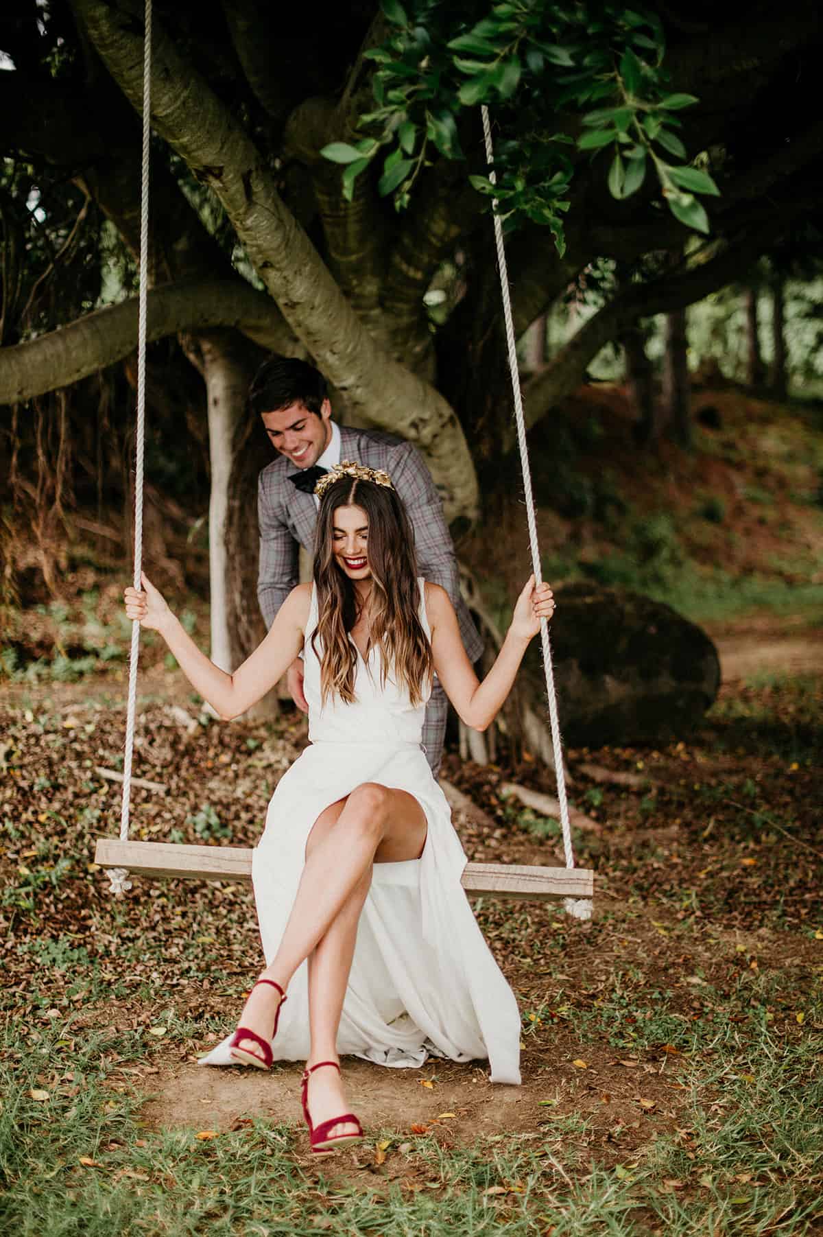 groom pushing bride on a swing