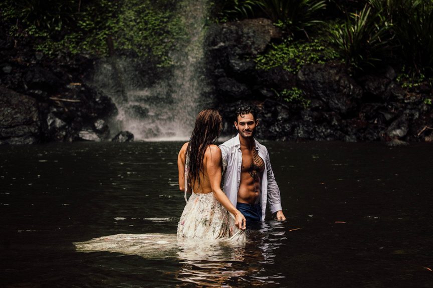 Couple standing in waterfall