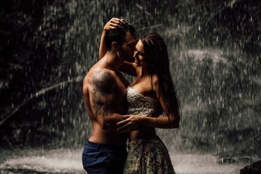 Couple embracing under waterfall