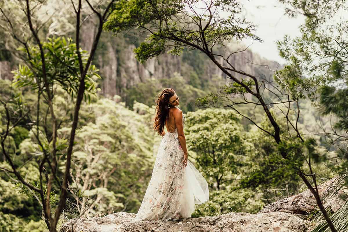 Bride on rock outlook in rainforest
