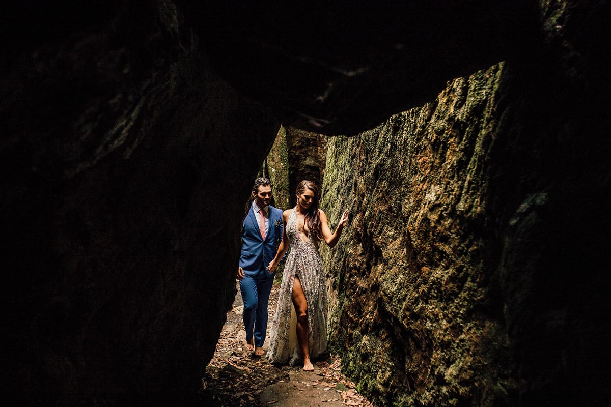 Couple walking near rock formation in rainforest