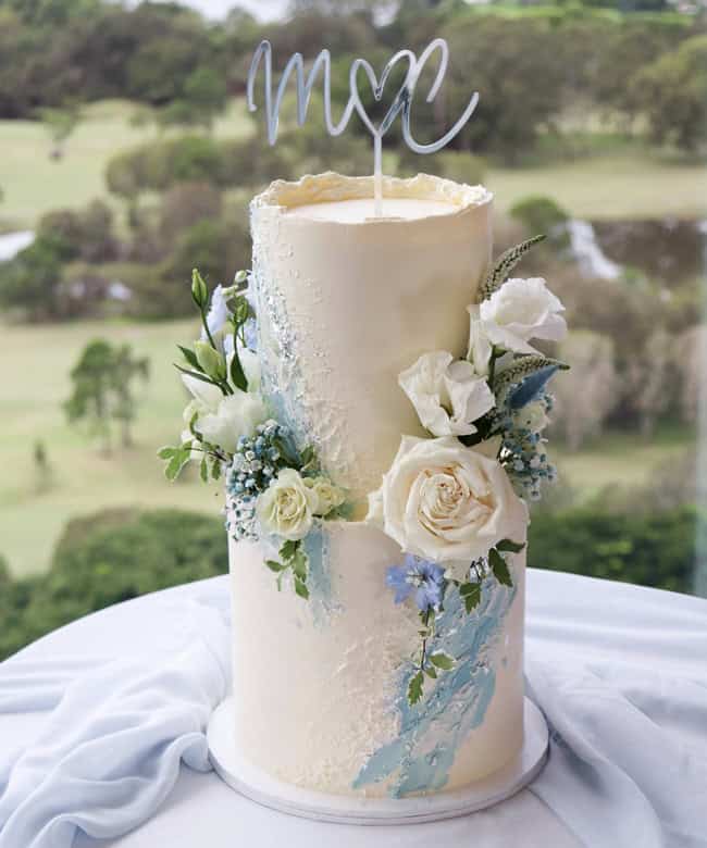 Baby blues on creamy white — pure delight. Milk & Honey Cake Creative topped off this beauty with florals from Twigs Florist.